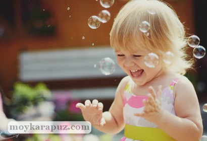Девочка играет с мыльными пузырями