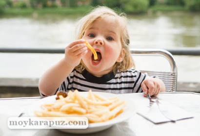 Девочка кушает картофель фри