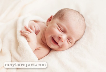 Новорожденный улыбается