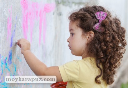 Девочка рисует левой рукой