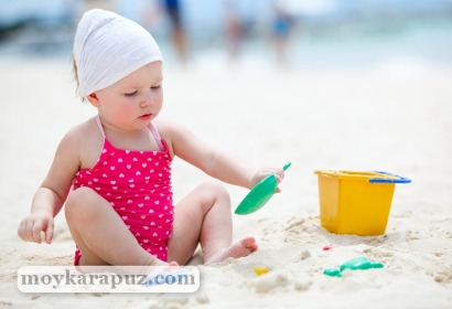 Маленькая девочка играет на пляже